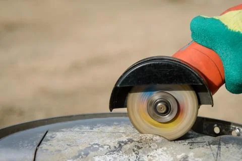 Worker cuts in metal with an angle grinder Stock Photos