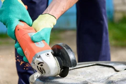 Worker cuts in metal with an angle grinder Stock Photos