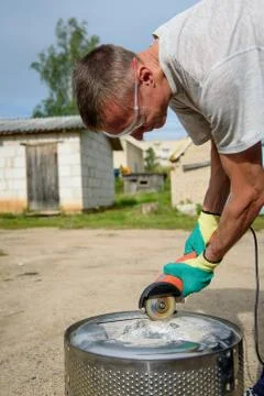Worker cuts in metal with an angle grinder Stock Photos