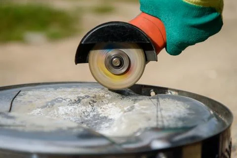 Worker cuts in metal with an angle grinder Stock Photos