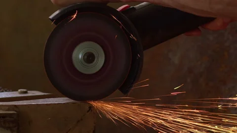 A worker cuts metal with a grinder. Flying sparks, slow motion. Stock Footage 158333825