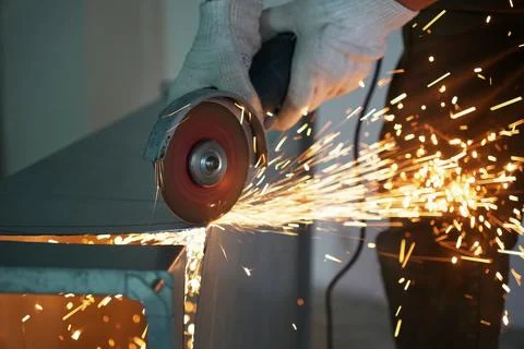 Worker cuts a metal part with an angle grinder Stock Photos