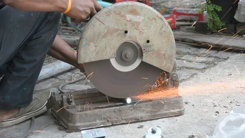 Worker cuts a metal pipe with some electric device or appliance Stock Footage 83787161
