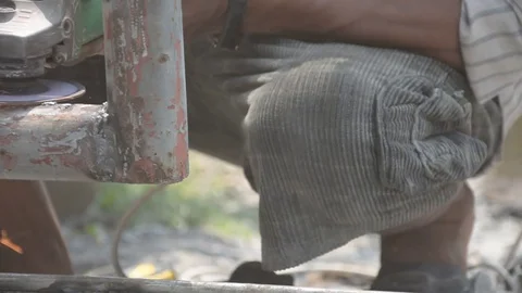 Worker cuts a metal pipe with some electric device or applianc Stock Footage 83787629