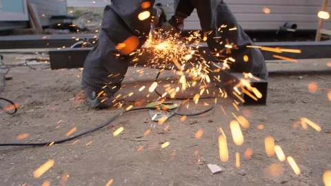 A worker cuts a metal profile with an angle grinder. Video stock 230983043