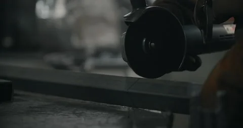 Worker cuts a metal profile with a grinder in slow motion with a flying stream Stock Footage 151639802