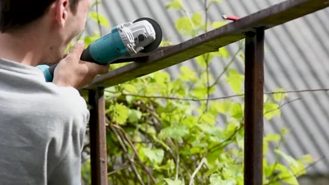 A worker cuts a metal structure With A Disk Machine. sparks while to cut metal Stock Footage 275810024