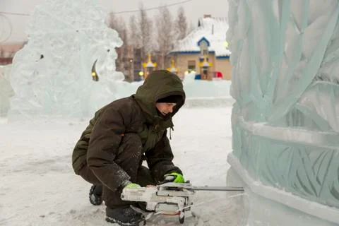 Worker cuts a niche under a chainsaw spotlight 写真素材