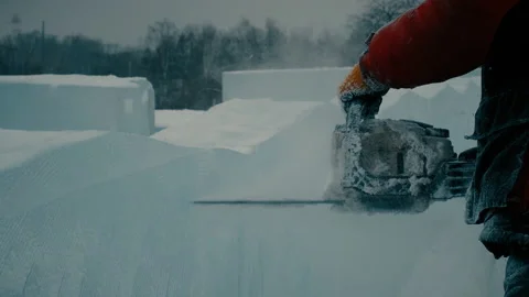 A worker cuts a panel of ice with gasoline, a city decoration for Christmas Stock Footage 121798028