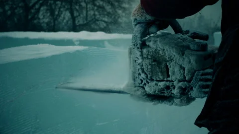 A worker cuts a panel of ice with gasoline, a city decoration for Christmas Stock Footage 121863233
