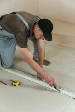 Worker cuts a piece of drywall Stock Photos