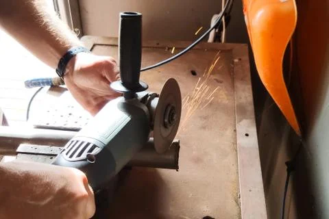 Worker cuts off piece of pipe with grinder Foto stock