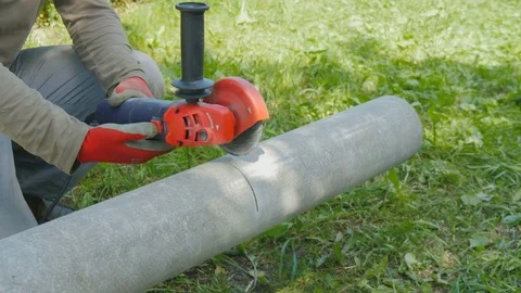 The worker cuts the pipe from asbestos, into two parts. Stock Footage 77035543