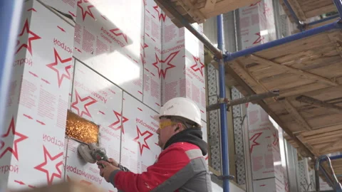 Worker cuts rectangular window in fragile drywall structure Stockbeeldmateriaal 310243832