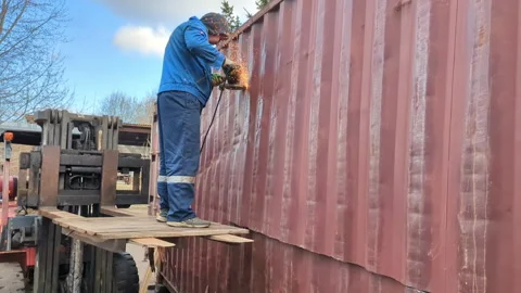 Worker cuts a shipping container with a metal saw. Stock Footage 306079079