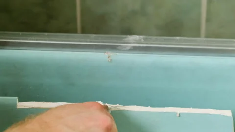 Worker cuts top of plasterboard panel for crafting wall shape Stock Footage 304407673