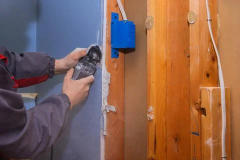 Worker cuts wall with power multi tool in construction site Stock Photos