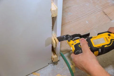 Worker cuts wood with saw while fitting pieces together in construction area Stock Photos