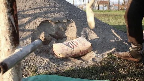 Worker is cutting the bag of cement with a shovel Stock Footage 75772476