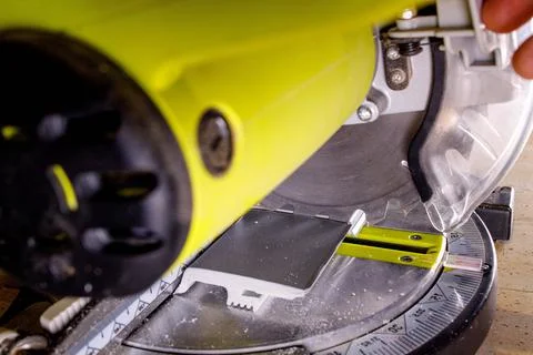 Worker cutting baseboard on the circular saw before installing Foto stock