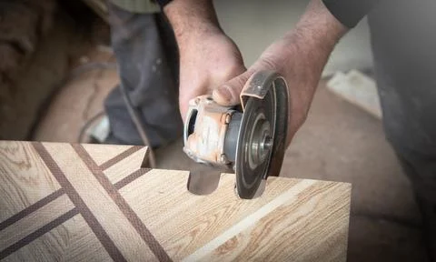 Worker cutting a ceramic tile with a grinder. Stock Photos