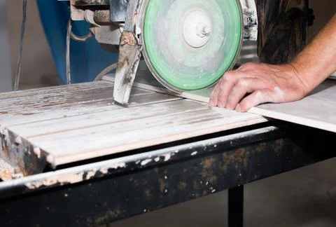 A worker is cutting a ceramic tile on a special electric wet water cutter s.. Stock Photos