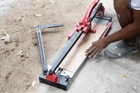 Worker cutting ceramic tile with tile cutter tool Stock Photos
