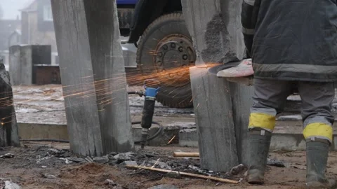 Worker cutting concrete piles with cutter or circular saw on construction site Stock Footage 158050868