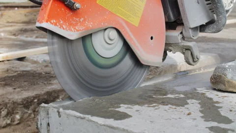 Worker cutting concrete slab with circular saw Stock Footage 310950529