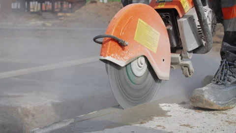 Worker cutting concrete slab with circular power saw Stock Footage 310950930