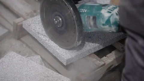 Worker cutting concrete tiles with a grinder tool at a construction site, slo Stock Footage 304354611