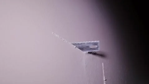 Worker Cutting Drywall Opening With Hand Saw During Interior Renovation Task Stock Footage 337573027