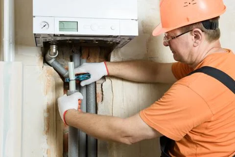 The worker is cutting off the excess part of the pipe. Foto stock