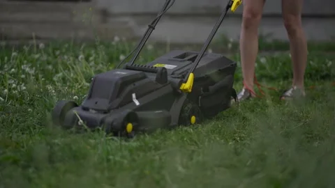 Worker cutting grass in private yard modern electric black trimmer. Mowing high Stock Footage 194483353