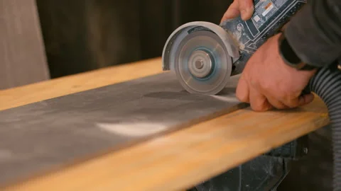 Worker cutting grey tile with electric angle grinder. Close up of construction Stock Footage 334063032