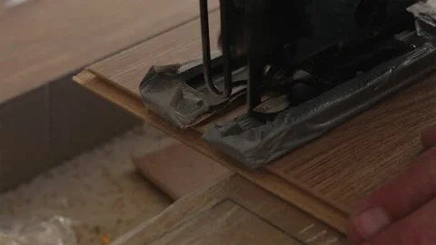 Worker cutting laminate flooring plank with electric jigsaw 스톡 동영상 346159842