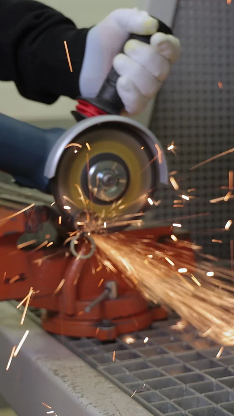 Worker cutting metal with an angle grinder generating vivid bright sparks, close Stock Footage 307968177