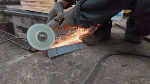 Worker cutting metal bar with angle grinder producing sparks 스톡 동영상 333697390
