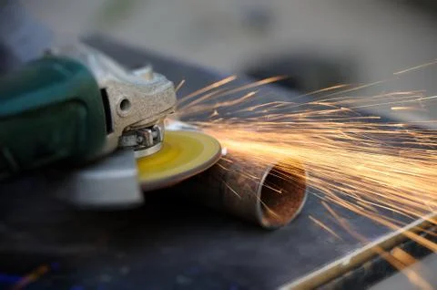 Worker cutting metal with grinder Stock Photos