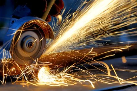 Worker cutting metal with grinder Stock Photos