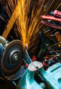 Worker cutting metal with grinder. Sparks while grinding iron. Selective low  Stock Photos