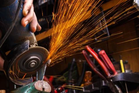 Worker cutting metal with grinder. Sparks while grinding iron. Selective low  Stock Photos