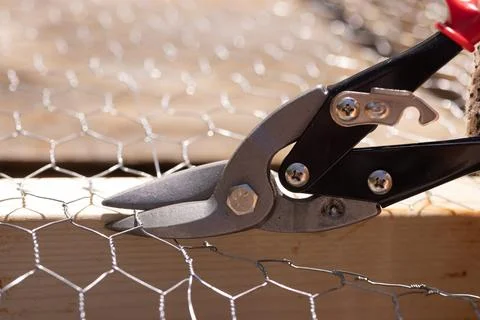 Worker cutting metal mesh with using scissors for a metal Stock Photos