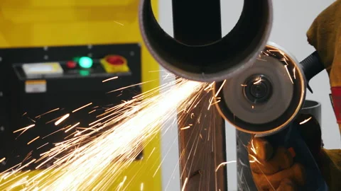 Worker cutting metal pipe with angle grinder producing sparks. 스톡 동영상 347790815