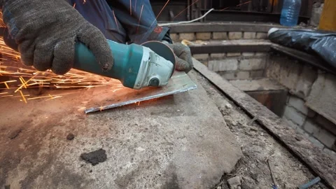 Worker cutting metal plate with angle grinder creating sparks Stock Footage 333696837