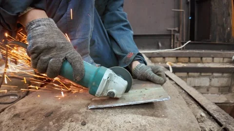 Worker cutting metal plate with angle grinder creating sparks Видео 335284334
