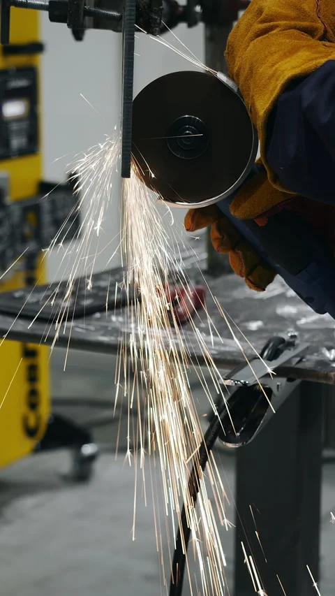 Worker cutting metal rod with angle grinder producing sparks 스톡 동영상 347775971
