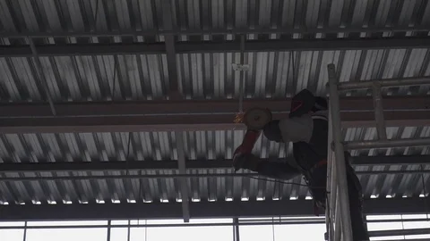 Worker cutting the metal structure through angular grinding machine, sparks. Video stock 73029633