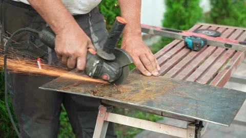 Worker cutting metal tube using an Angle Grinder. Bright sparks and flashes Video stock 258645526
