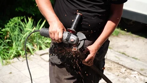 Worker cutting metal tube using an Angle Grinder. Bright sparks and flashes Stock-Footage 258645664
